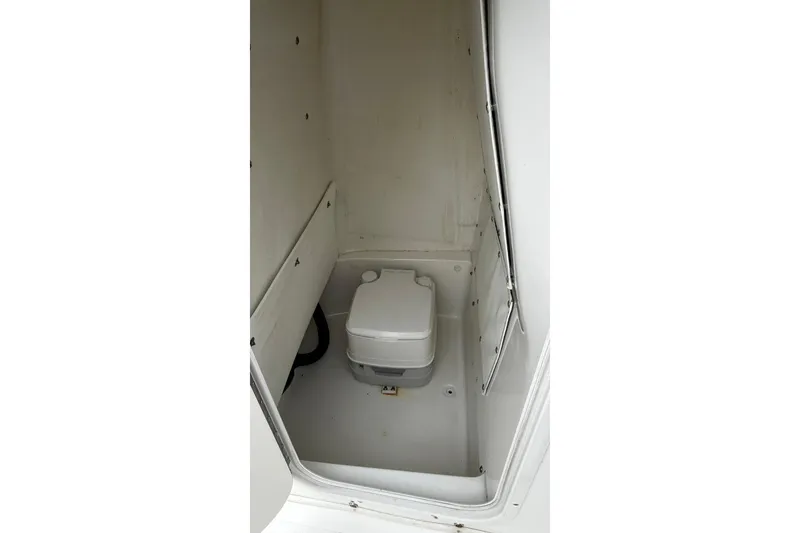 Slide: The Image of 2015 NauticStar 231 Coastal boat interior with compact marine toilet. - 20