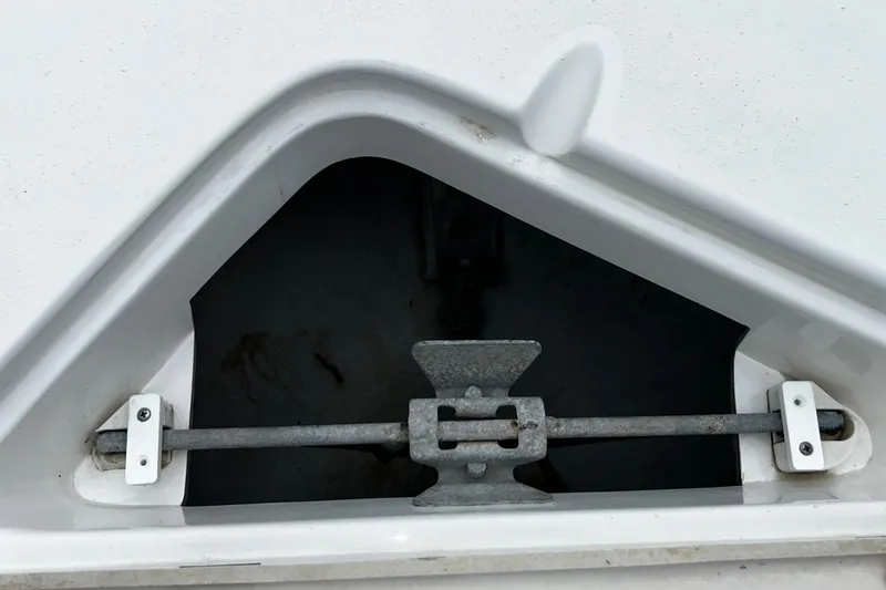 Slide: The Image of Anchor compartment of 2015 NauticStar 231 Coastal boat, featuring metal securing bar. - 23