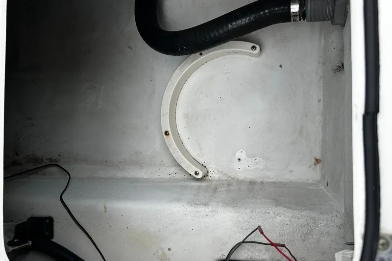 Slide: The Image of Interior view of a 2015 NauticStar 231 Coastal boat compartment with wiring and tubing. - 26