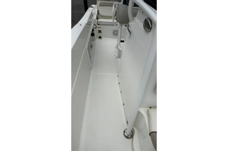 Slide: The Image of 2015 NauticStar 231 Coastal boat interior with white seating and clean deck. - 27
