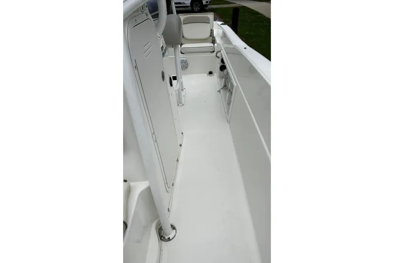 Slide: The Image of 2015 NauticStar 231 Coastal boat interior, featuring white seating and storage compartments. - 28