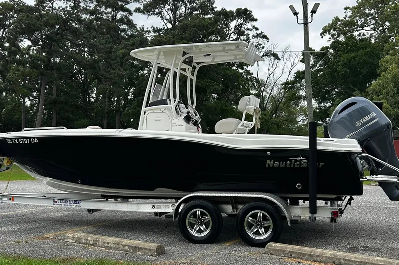 Slide: The Image of 2015 NauticStar 231 Coastal boat on trailer with Yamaha engine, parked outdoors. - 3