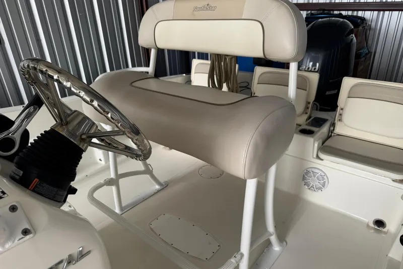 Slide: The Image of 2015 NauticStar 231 Coastal boat interior with steering wheel and seating. - 31