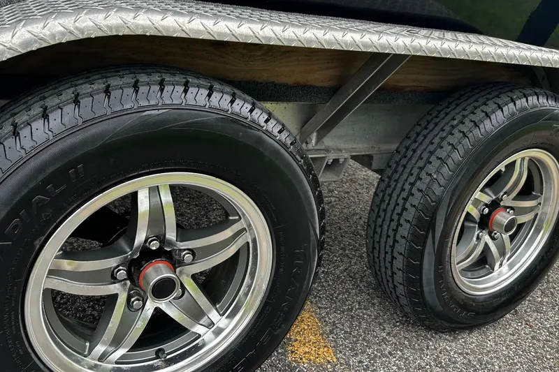 Slide: The Image of Trailer wheels of a 2015 NauticStar 231 Coastal boat on pavement. - 35