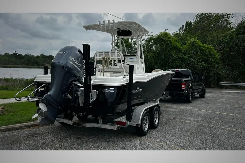 Slide: The Image of 2015 NauticStar 231 Coastal boat on trailer, parked near a lake with a truck. - 4