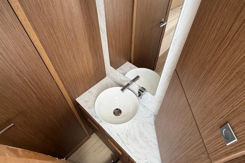 Slide: The Image of Modern bathroom vanity with round sink and wood paneling in Jupiter 43, 2026 model. - 12