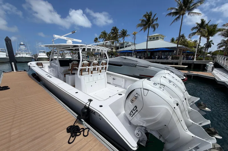Slide: The Image of 2026 Jupiter 43 boat on water, featuring sleek design and multiple outboard engines. - 2
