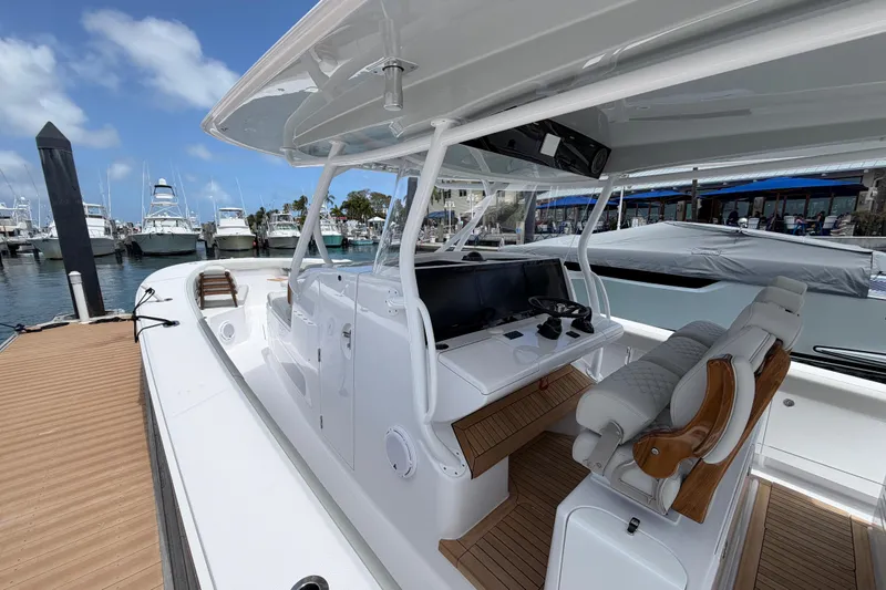 Slide: The Image of 2026 Jupiter 43 boat docked, featuring sleek design and comfortable seating under a sunny sky. - 6