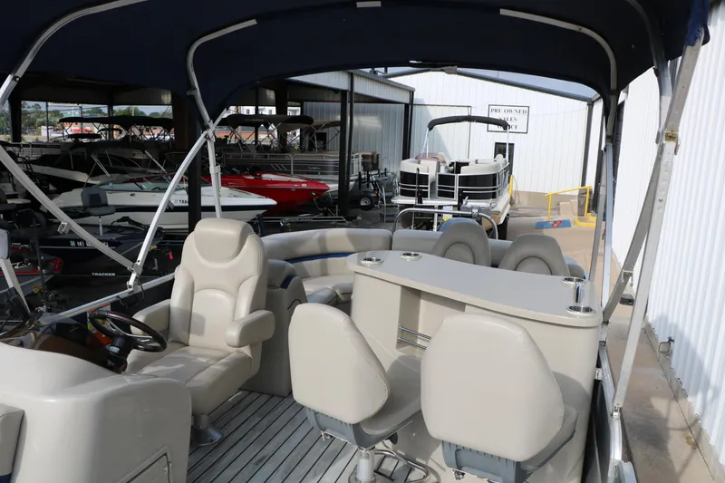 Slide: The Image of 2017 Berkshire 22 E CTS pontoon boat interior with seating and helm, displayed in a showroom. - 24