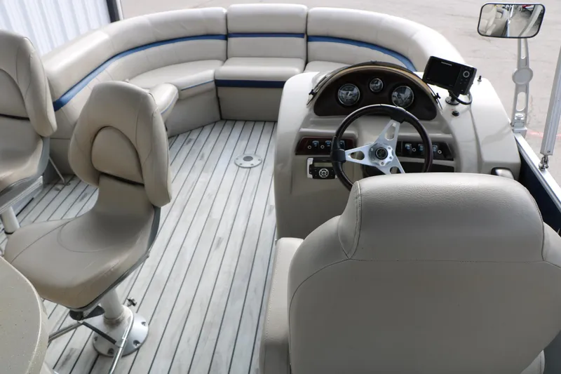 Slide: The Image of Interior of a 2017 Berkshire 22 E CTS pontoon boat with beige seating and steering console. - 32