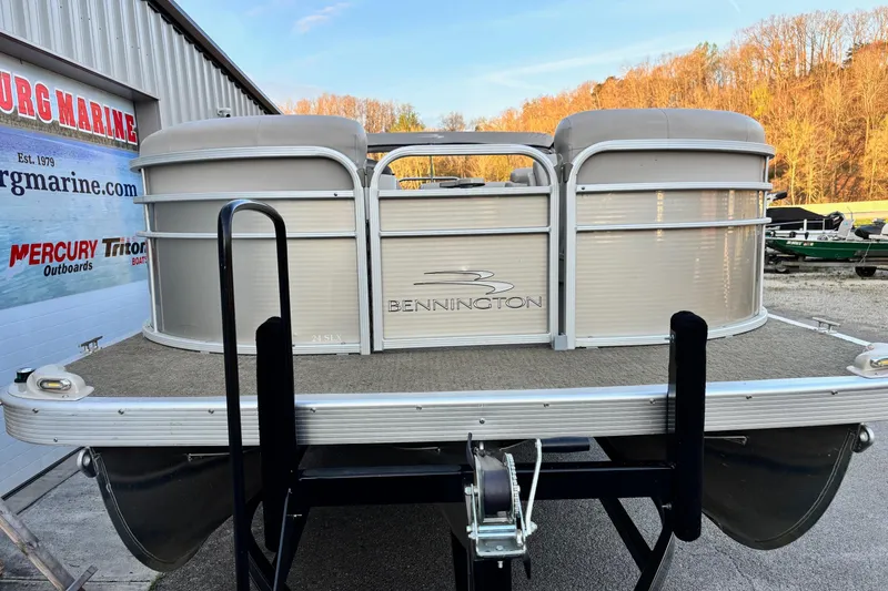 Slide: The Image of 2015 Bennington 24 SLX pontoon boat on trailer, parked outside dealership. - 2