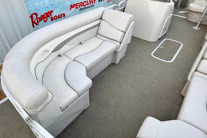 Slide: The Image of 2015 Bennington 24 SLX boat interior with beige seating and carpeted floor. - 4