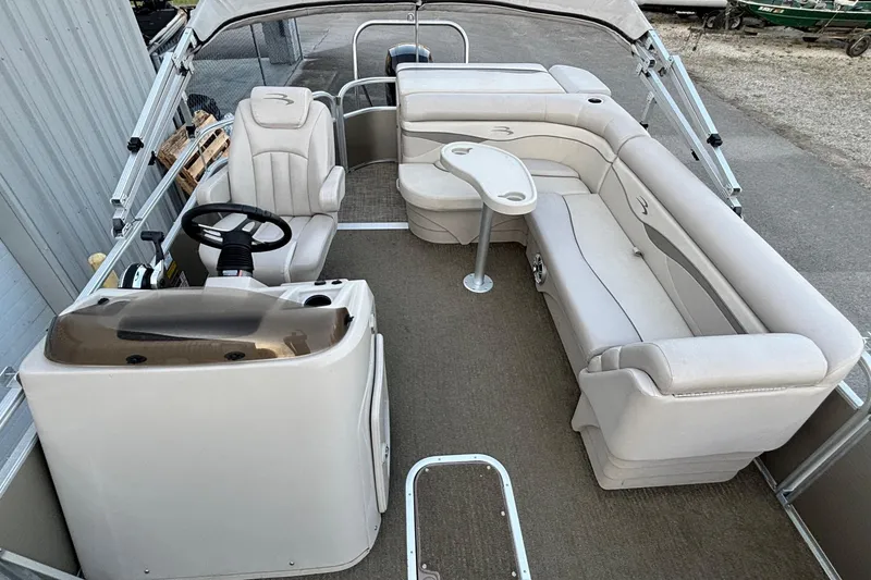 Slide: The Image of 2015 Bennington 24 SLX pontoon boat interior with beige seating and steering console. - 7