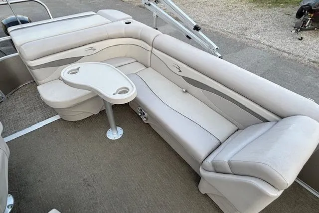 Slide: The Image of 2015 Bennington 24 SLX pontoon boat interior with beige seating and table. - 8