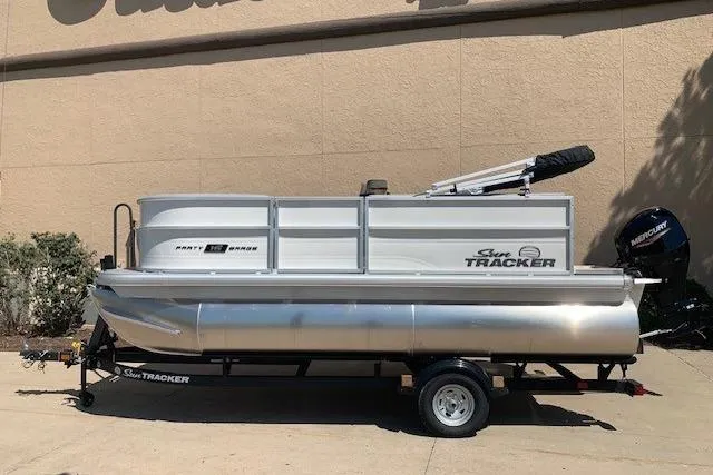 Slide: The Image of 2026 Sun Tracker Party Barge 16 DLX pontoon boat on trailer, parked outdoors. - 19