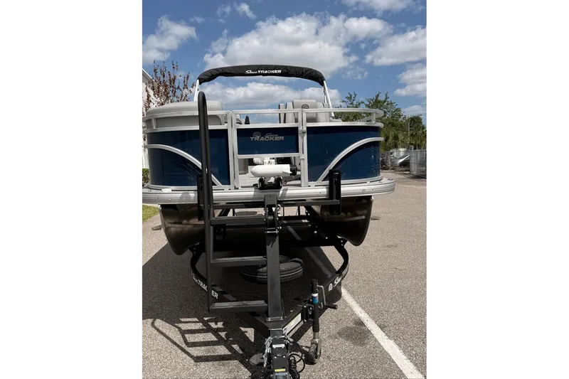 Slide: The Image of 2026 Sun Tracker SportFish 20 DLX pontoon boat on trailer under blue sky. - 99