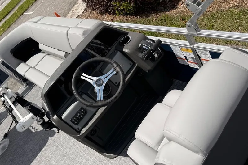 Slide: The Image of Interior view of 2026 Sun Tracker SportFish 20 DLX pontoon boat with steering wheel and seating. - 95
