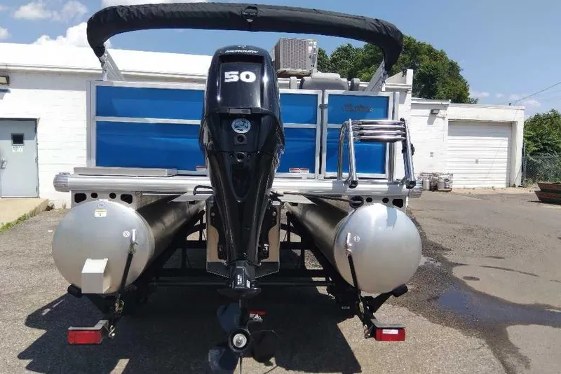 Slide: The Image of 2026 Sun Tracker Party Barge 16 DLX pontoon boat with Mercury 50 engine, parked outdoors. - 7