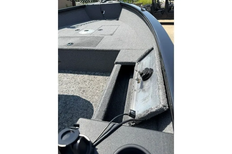 Slide: The Image of 2025 Tracker Super Guide V-16 T boat interior with storage compartments and carpeted flooring. - 8