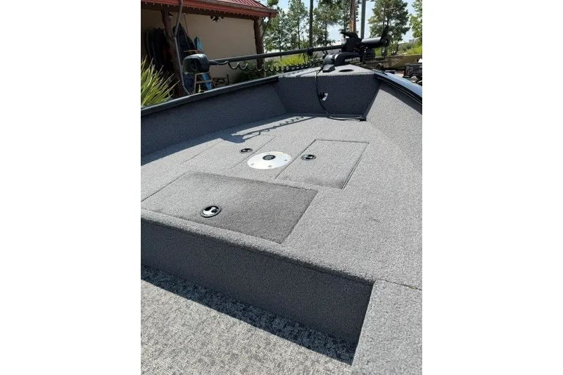 Slide: The Image of 2025 Tracker Super Guide V-16 T boat deck with carpeted surface and storage compartments. - 10