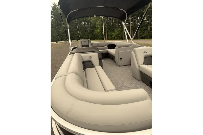 Slide: The Image of 2026 Sun Tracker Party Barge 20 DLX with spacious seating and canopy in a wooded area. - 10