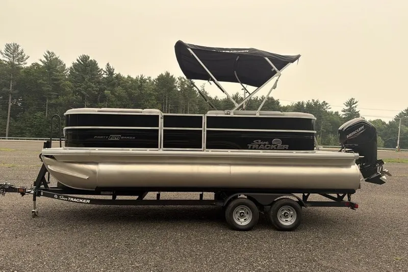 Slide: The Image of 2026 Sun Tracker Party Barge 20 DLX pontoon boat on trailer, parked outdoors. - 3