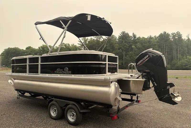 Slide: The Image of 2026 Sun Tracker Party Barge 20 DLX pontoon boat with Mercury outboard motor on trailer. - 4