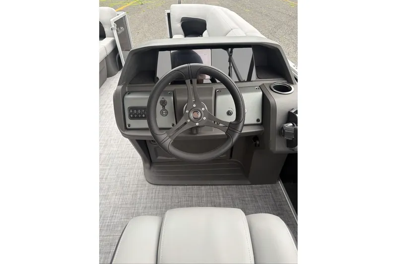 Slide: The Image of 2026 Sun Tracker Party Barge 20 DLX steering console with modern controls and seating. - 11