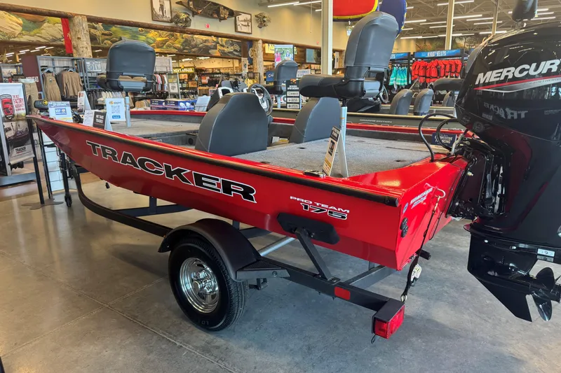 Slide: The Image of 2026 Tracker Pro Team 175 boat displayed in showroom, featuring red exterior and Mercury engine. - 49