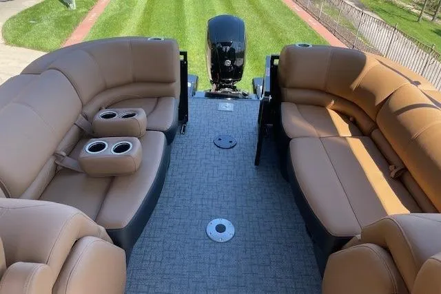 Slide: The Image of Luxurious 2026 Regency 230 DL pontoon boat interior with plush seating and cup holders. - 2