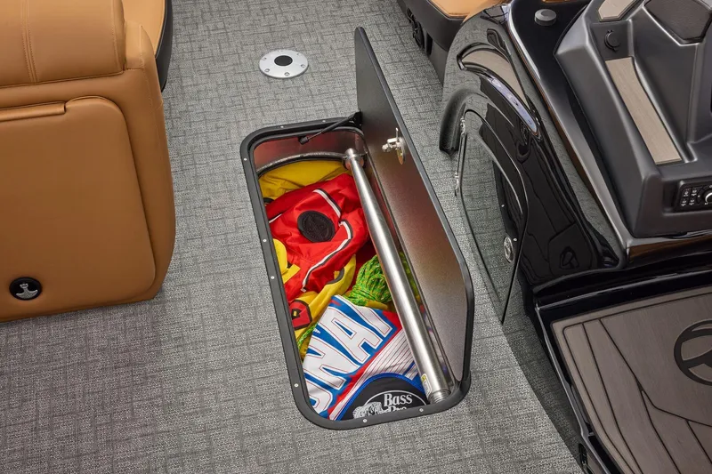 Slide: The Image of Open storage compartment on 2026 Regency 230 DL boat with colorful items inside. - 28