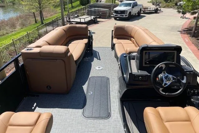 Slide: The Image of 2026 Regency 230 DL pontoon boat with tan seating and modern dashboard. - 6