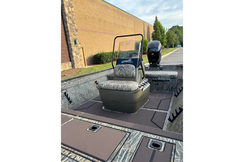 Slide: The Image of 2026 Tracker Grizzly 2072 CC boat interior with camo seating and steering console. - 3