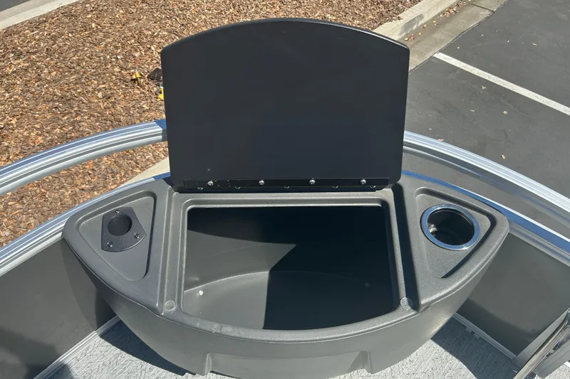Slide: The Image of 2026 Sun Tracker Bass Buggy 18 DLX storage compartment with cup holders, open lid view. - 11