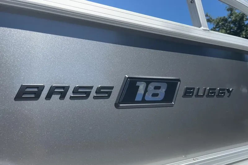 Slide: The Image of 2026 Sun Tracker Bass Buggy 18 DLX logo on metallic surface under clear sky. - 33