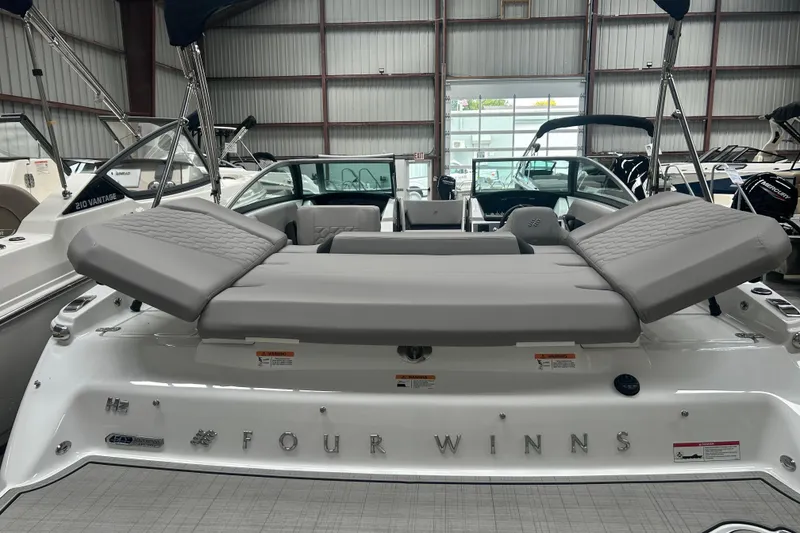 Slide: The Image of 2025 Four Winns H2 boat with sleek seating in a showroom. - 7