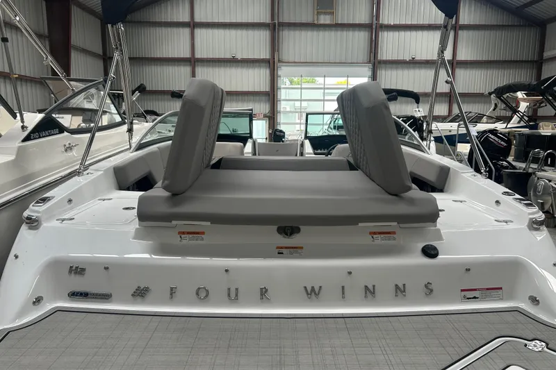 Slide: The Image of 2025 Four Winns H2 boat interior with cushioned seating in a showroom. - 8