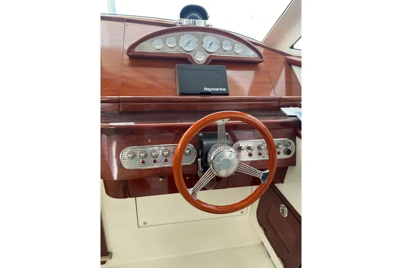Slide: The Image of 2001 Santa Cruz Coastal Flyer 41 dashboard with wooden steering wheel and Raymarine display. - 7