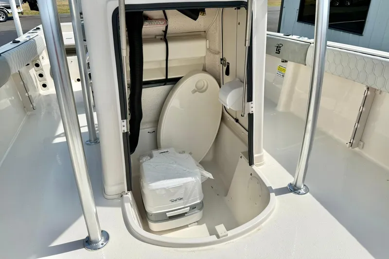 Slide: The Image of 2026 Carolina Skiff 21 Ultra Elite boat interior with portable toilet and storage area. - 19