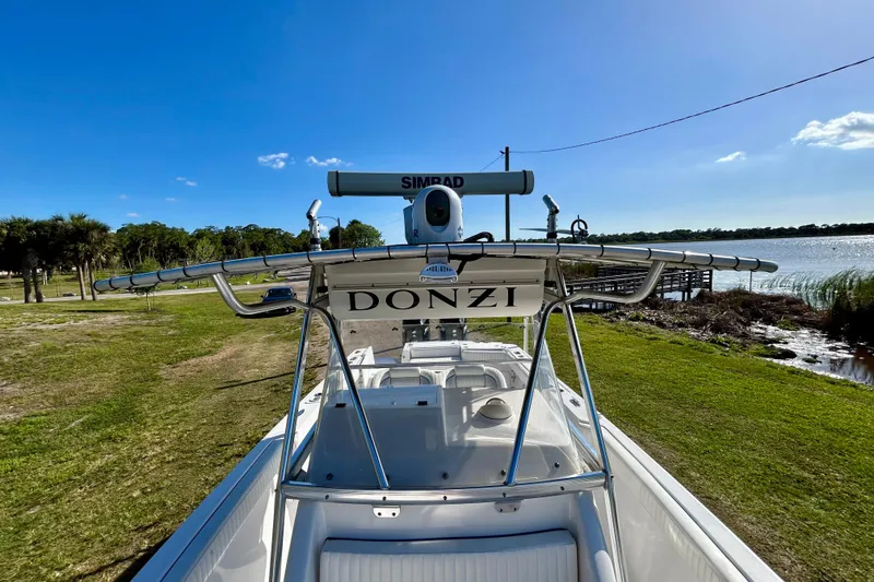 Slide: The Image of 2003 Donzi 32 ZF Open boat docked by a scenic lakeside. - 10