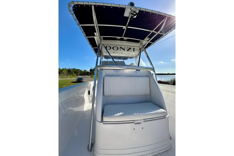 Slide: The Image of 2003 Donzi 32 ZF Open boat with seating and canopy, docked by a scenic lake. - 11