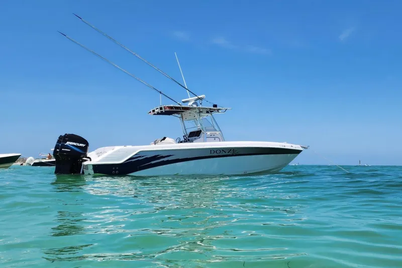 Slide: The Image of 2003 Donzi 32 ZF Open boat anchored in clear blue water under a sunny sky. - 2