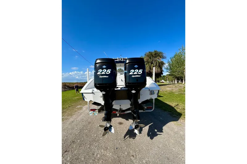 Slide: The Image of 2003 Donzi 32 ZF Open boat with twin 225 OptiMax engines, parked on grass. - 3