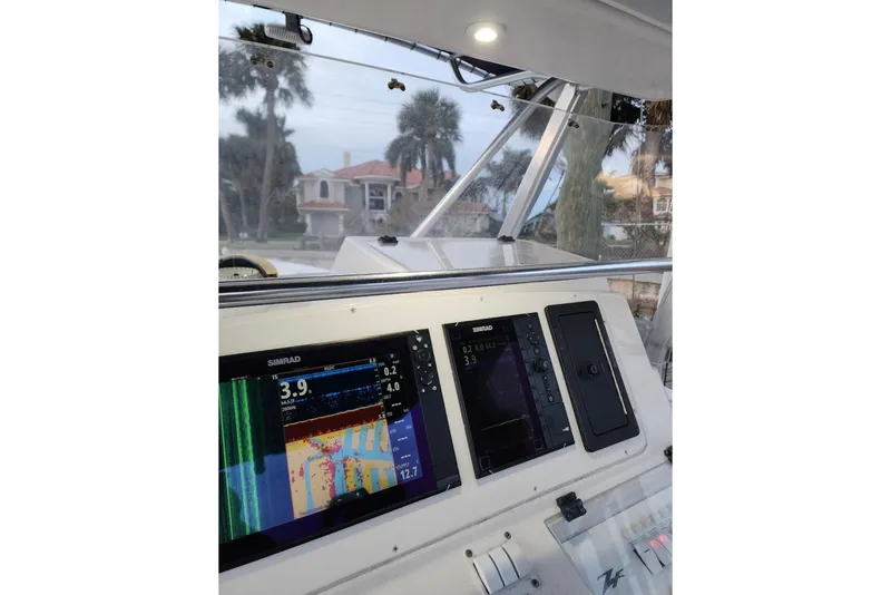 Slide: The Image of 2003 Donzi 32 ZF Open boat dashboard with navigation screens and controls. - 30