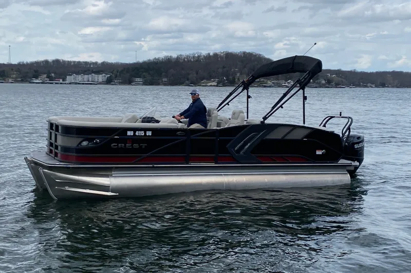 The Image of 2021 Crest Caribbean Platinum 230 SLC pontoon boat on a lake with a person onboard. - 1