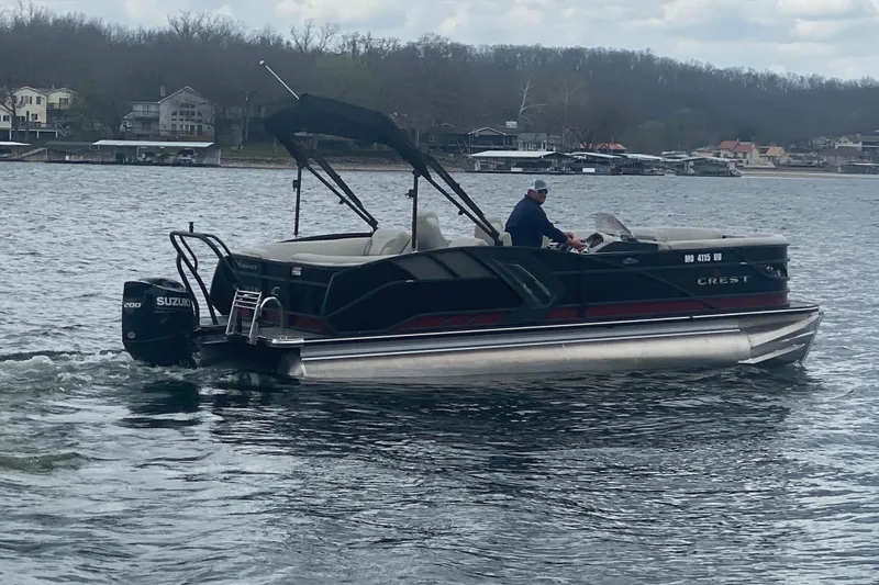 Slide: The Image of 2021 Crest Caribbean Platinum 230 SLC pontoon boat cruising on a lake. - 4