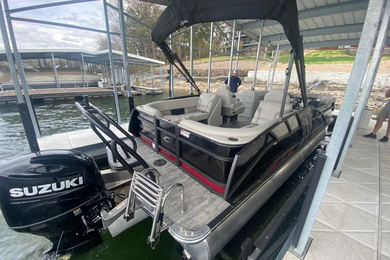 Slide: The Image of 2021 Crest Caribbean Platinum 230 SLC pontoon boat docked with Suzuki outboard motor. - 6