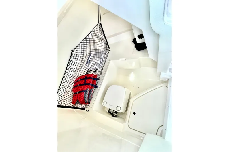 Slide: The Image of 2024 Sea Ray SDX 250 Outboard interior with life jacket storage and compact toilet. - 16