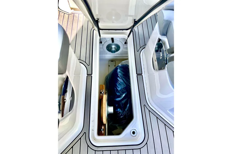 Slide: The Image of 2024 Sea Ray SDX 250 Outboard storage compartment with open hatch and visible contents. - 17
