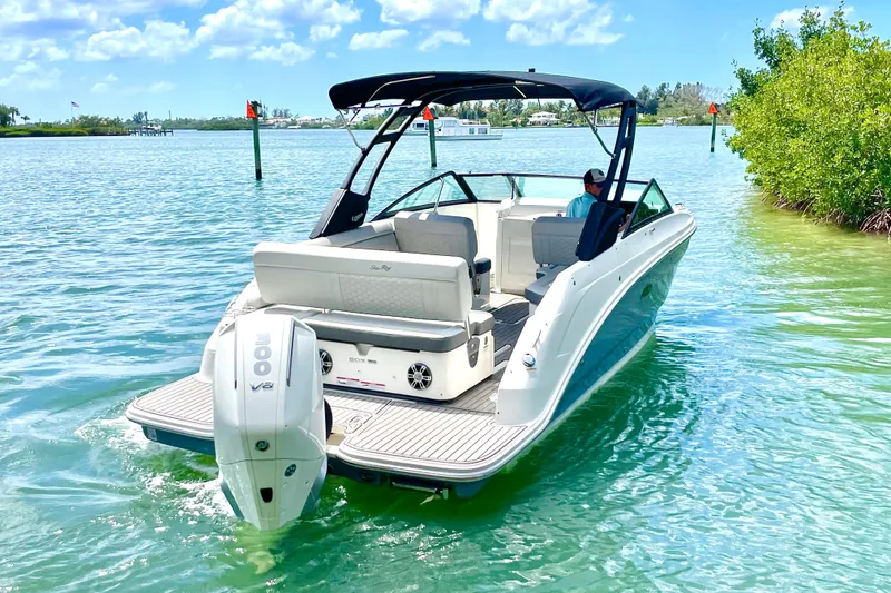 Slide: The Image of 2024 Sea Ray SDX 250 Outboard boat cruising on clear blue water under a sunny sky. - 3